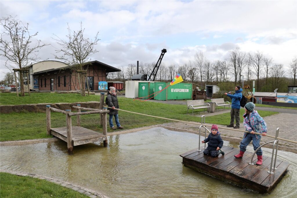 Fiete (links) und Hanna Keim haben trotz Regen und Wind Spaß auf dem Wasserspielplatz. Mutter Julia Keim schaut zu. Vater Ulf Klinkhammer lässt seinen Drachen steigen. Fiete (links) und Hanna Keim haben trotz Regen und Wind Spaß auf dem Wasserspielplatz. Mutter Julia Keim schaut zu. Vater Ulf Klinkhammer lässt seinen Drachen steigen.