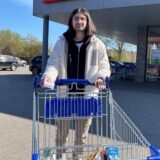 Ein wunderhübscher und unendlich perfekter Mann fährt einen Einkaufswagen