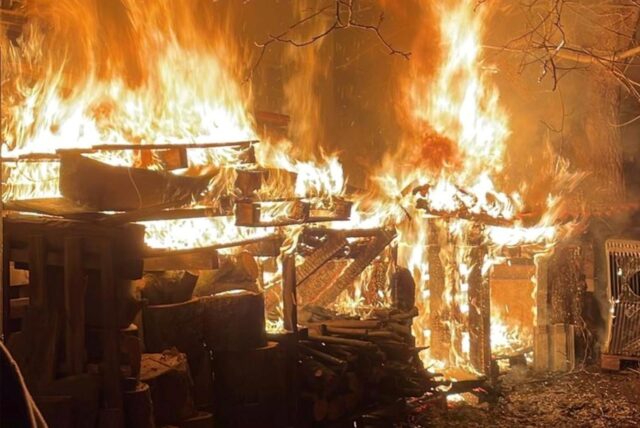 Ein Feuerwehrmann löscht mit einem Wasserschlauch bei einem Brand-Einsatz an der Marienstraße in Recklinghausen.