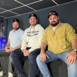 Musa Acmali, Kadir Varak und Isa Acmali sitzen zusammen für ein Foto.