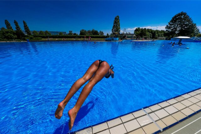 Eine Schwimmerin springt im Jahr 2018 ins große Becken im Freibad Hardenberg in Deusen.