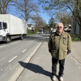 Michael Bauer steht am Neuen Weg, im Hintergrund sind zwei Lkw und ein Bus zu sehen.