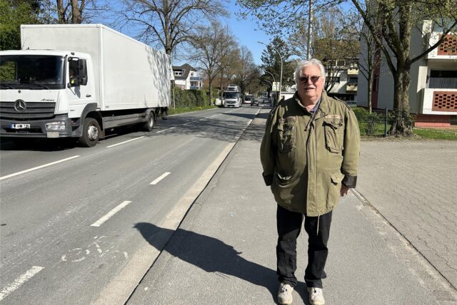 Michael Bauer steht am Neuen Weg, im Hintergrund sind zwei Lkw und ein Bus zu sehen.
