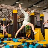 Menschen springen auf einem Trampolin-Parcours.