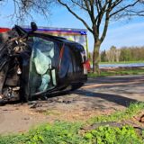 Ein deformierter Pkw liegt auf einer Allee auf der Seite.