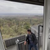 Mann auf einem Feuerwachturm blickt in den Wald