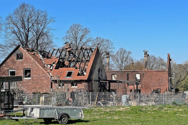 Mauerreste und verkohlte Dachbalken eines abgebrannten Bauernhofs in Unna ragen in die Höhe