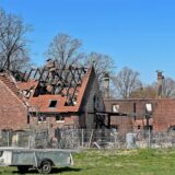Mauerreste und verkohlte Dachbalken eines abgebrannten Bauernhofs in Unna ragen in die Höhe