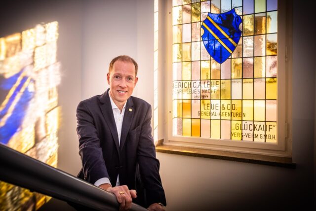 Joachim Nill steht vor einem historischen Fenster am Hauptsitz von Leue & Nill in der Hohenzollernstraße in Dortmund.