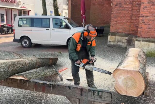 Ernst Franz mit Kettensäge an einem Baum in Schutzausrüstung auf dem Marktplatz in Haltern