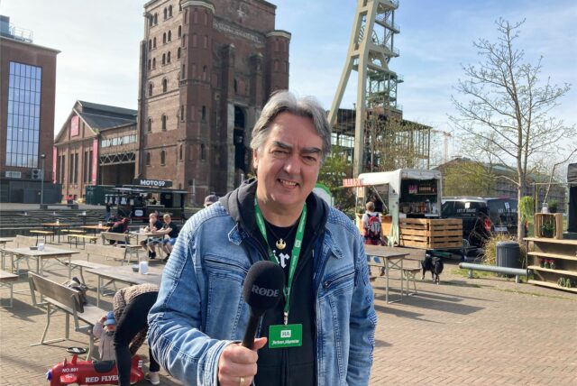 Redakteur Patrick Köllner mit einem Mikrofon in der Hand. Er berichtet vom ersten Feierabendmarkt auf dem Gelände der Zeche Ewald in Herten-Süd.