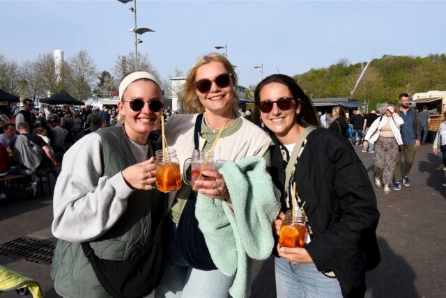 Drei Besucherinnen des Feierabendmarktes auf Zeche Ewald in Herten-Süd stoßen mit einem Cocktail an.