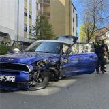 Ein blauer Mini nach steht nach einem Unfall auf der Straße.