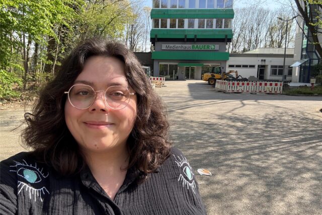 Laura Wunderlich steht vor dem Medienhaus-Bauer-Gebäude in Marl.