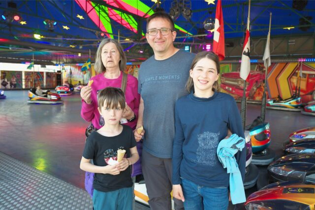 Eine Familie steht am Autoscooter auf der Palmkirmes in Recklinghausen.
