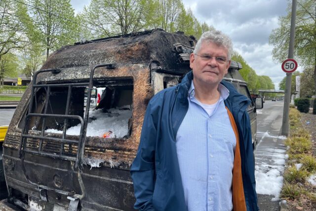 Thomas Doehring steht vor seinem ausgebrannten VW Bulli neben der B1 in Dortmund.