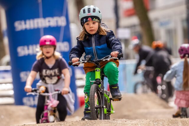 Ein Mädchen fährt mit einem Fahrrad über eine hügelige Piste auf dem E-Bike-Festival in Dortmund.