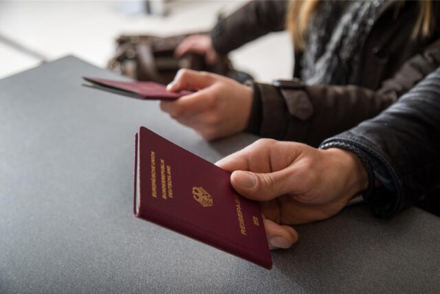 Ein Mann hält seinen Reisepass.