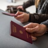 Ein Mann hält seinen Reisepass.
