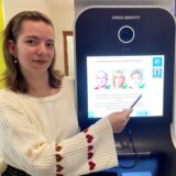 Lea Bazan, Mitarbeiterin im Bürgerbüro, zeigt, wie man am Bildautomaten zukünftig Passfotos erstellen kann.