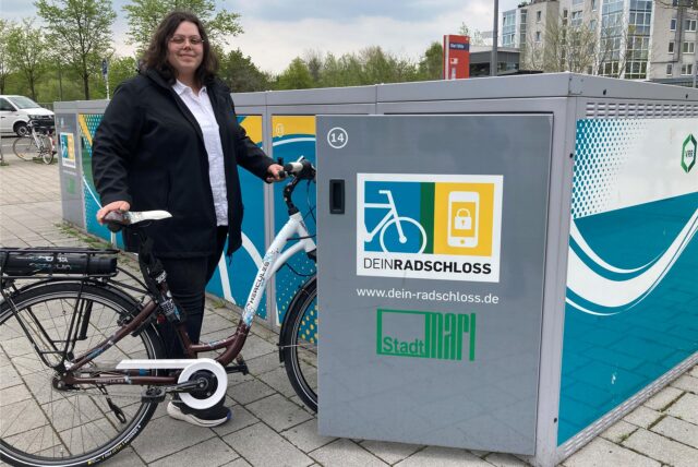 Laura Wunderlich schiebt ihr Fahrrad in eine geöffnete Fahrradbox in Marl-Mitte.
