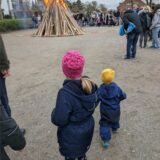 Zwei Kinder stehen vor einem Osterfeuer.