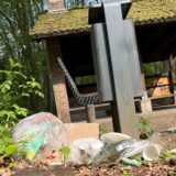 Plastikmüll liegt auf dem Boden vor einem Mülleimer.