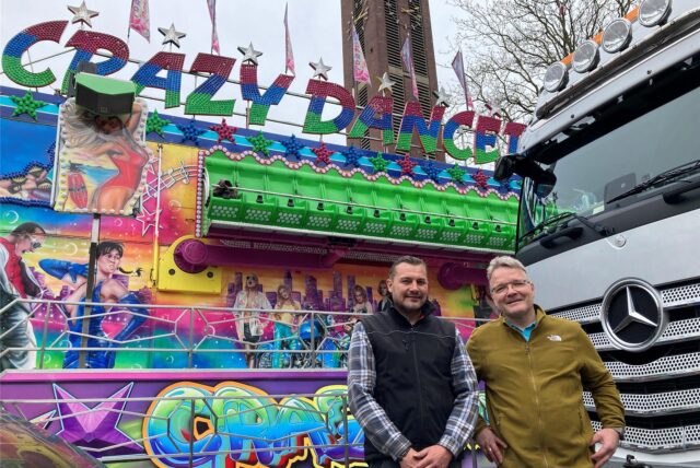 Zwei Schausteller vor einem Fahrgeschäft auf der Osterkirmes in Marl-Hüls.