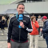 Tim Hübbertz steht mit einem Mikrofon in der Hand auf dem Platz der Alten Synagoge in Dortmund.