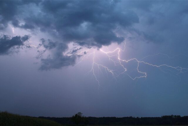 Große Blitze erstrecken sich über einen dunklen Himmel.