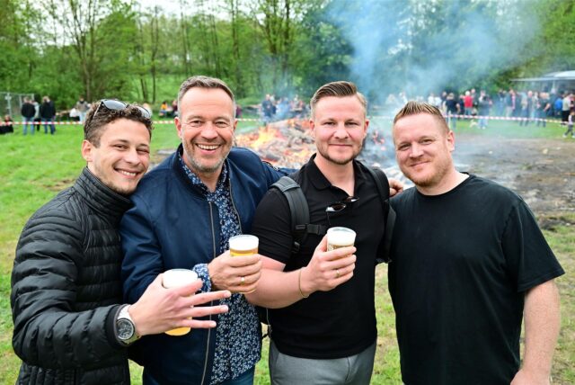 Vier Männer stehen vor dem Osterfeuer bei Bauer Südfeld in der Hertener Ried.