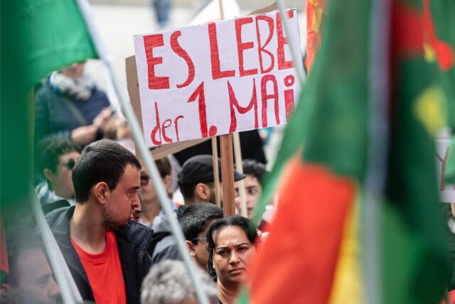 „Es lebe der 1. Mai“ steht auf dem Plakat eines Mannes, der an einer Kundgebung zum Tag der Arbeit teilnimmt.