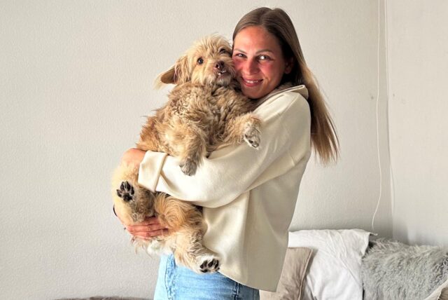Eine Frau mit einem Hund auf dem Arm