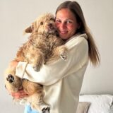 Eine Frau mit einem Hund auf dem Arm