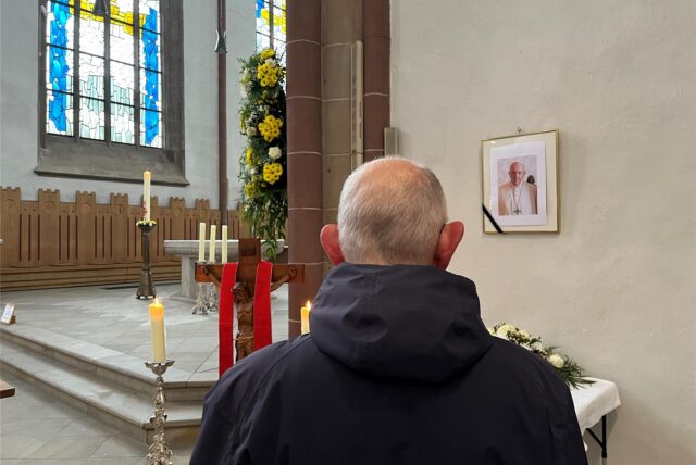 Ein Gläubiger steht in der Propsteikirche in Dortmund vor einem Foto des verstorbenen Papstes Franziskus.
