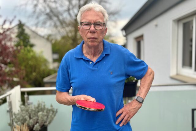 Wilfried Hamel steht mit einem Tischtennisschläger in der Hand auf seinem Balkon in Castrop-Rauxel.