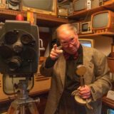Rainer Berkenhoff umgeben von alten Radios und Fernsehgeräten