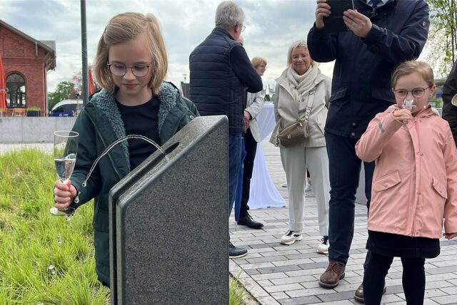 Mädchen zapft sich Wasser am Trinkwasserbrunnen in Dorsten