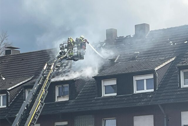 Feuerwehrleute in der Drehleiter am Dachstuhlbrand in der Ohmstraße im Einsatz noch.