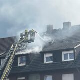 Feuerwehrleute in der Drehleiter am Dachstuhlbrand in der Ohmstraße im Einsatz noch.