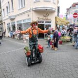 Ein als Gärtner verkleideter Mann rollt auf einem Segway während des Frühlingsfests in der Altstadt von Recklinghausen über die Heilige-Geist-Straße. (Archivbild)