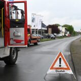 Ein Feuerwehrauto steht auf der Annabergstraße mit einem Schild auf dem Ölunfall steht.