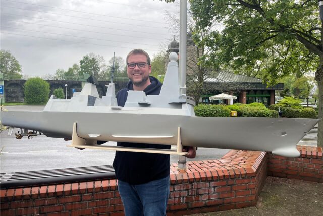 Markus Gremm steht mit seinem Schiffsmodell vor dem Schleusenpark in Waltrop.