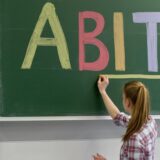 Eine Schülerin schreibt in einer Schule in NRW in großen und bunten Buchstaben das Wort „Abitur“ an die Tafel.