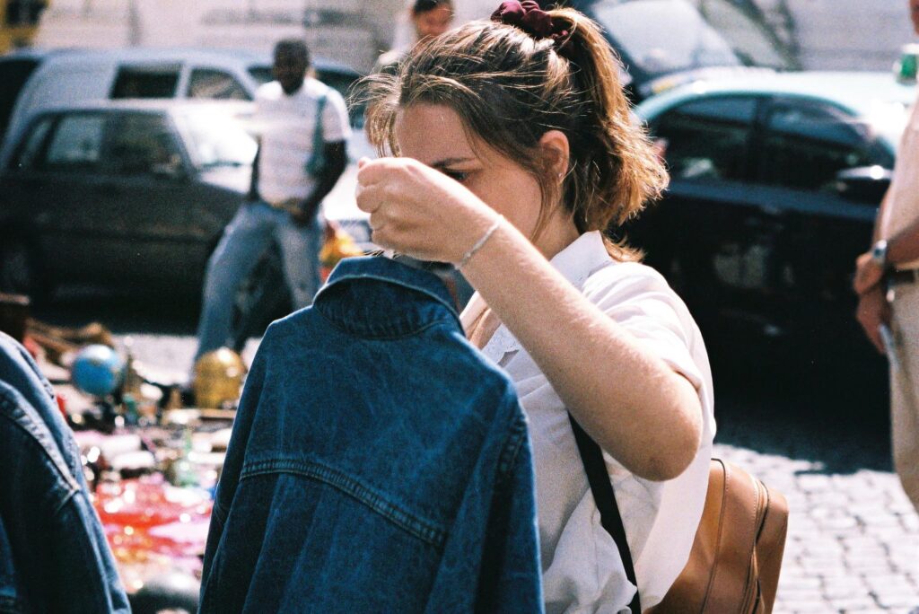 Eine Frau hält auf einem Trödelmarkt in NRW eine Jeansjacke in der Hand. Eine Frau hält auf einem Trödelmarkt in NRW eine Jeansjacke in der Hand.
