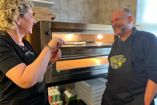 Sabrina Macher und Marco Paper vom Drügen-Pütt in Haltern stehen lachend vor ihrem neuen Pizzaofen.