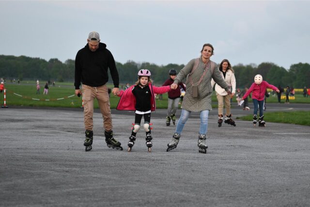 Eine Familie skatet über die Landebahn.
