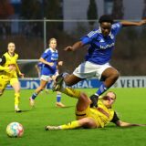 Eine Fußballerin von Schalke 04 springt über die Grätsche einer Spielerin des BVB.