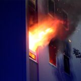Flammen schlagen aus einem Fenster einer Wohnung.