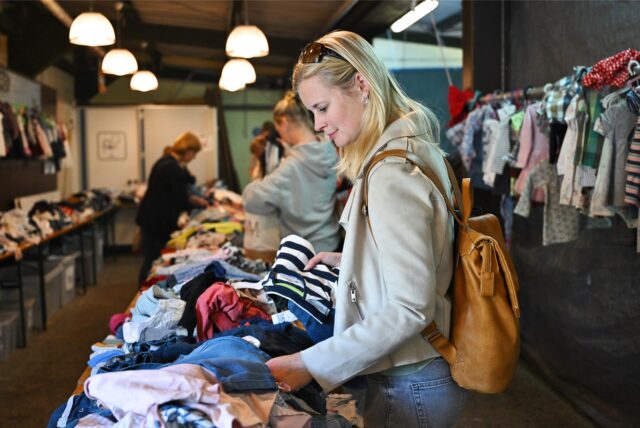 Frauen stöbern durch Kinderkleidung.